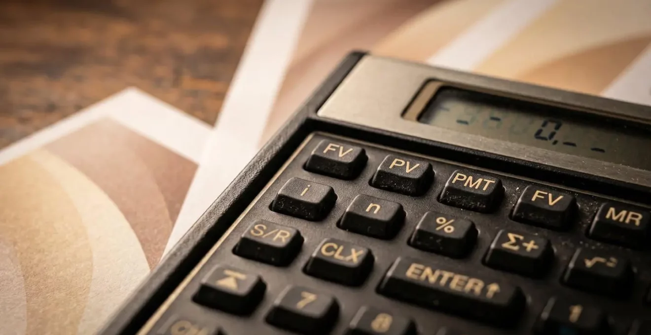 Vue macro détaillée d'une calculatrice avec documents d'assurance casco sur bureau, symbolisant le calcul du seuil de rentabilité