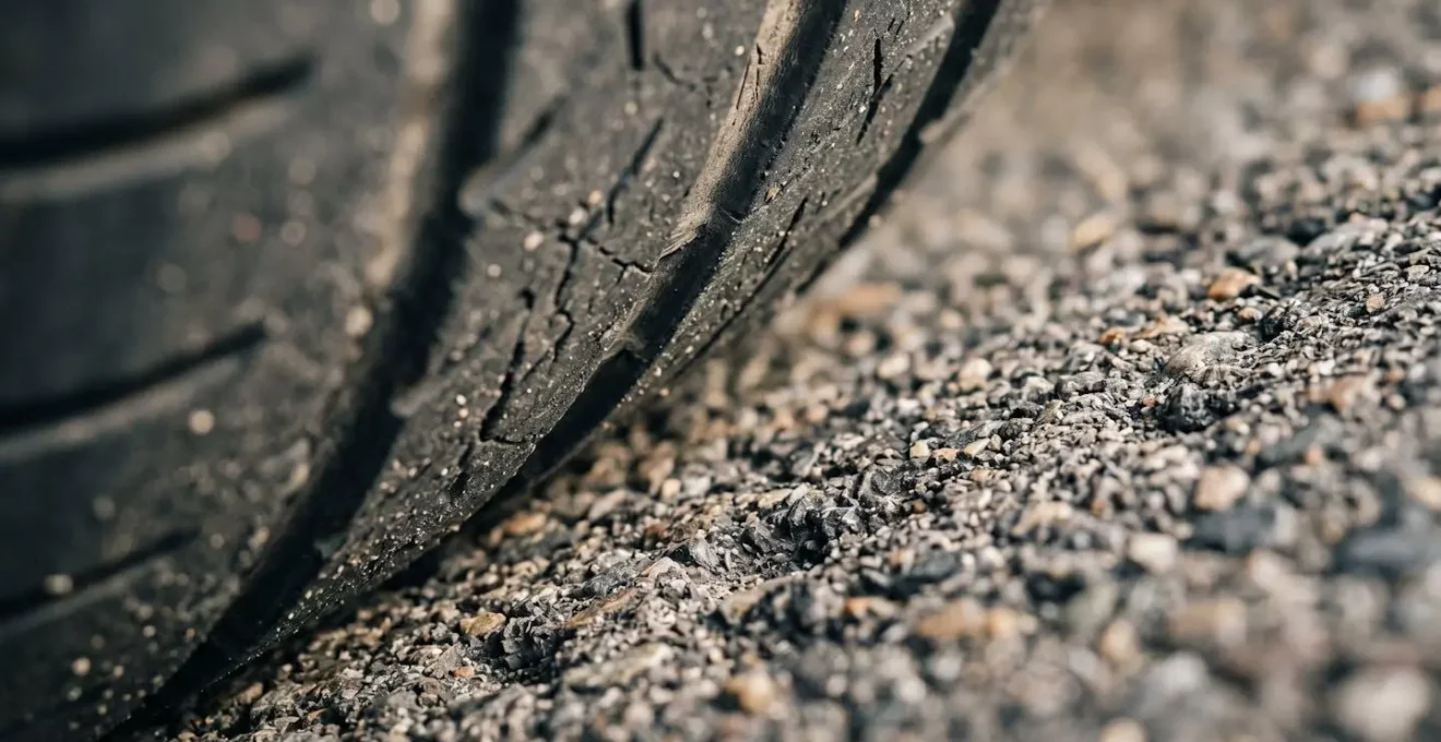 Détail macro de la surface d'un pneu avec texture de gomme illustrant l'adhérence nécessaire au freinage d'urgence