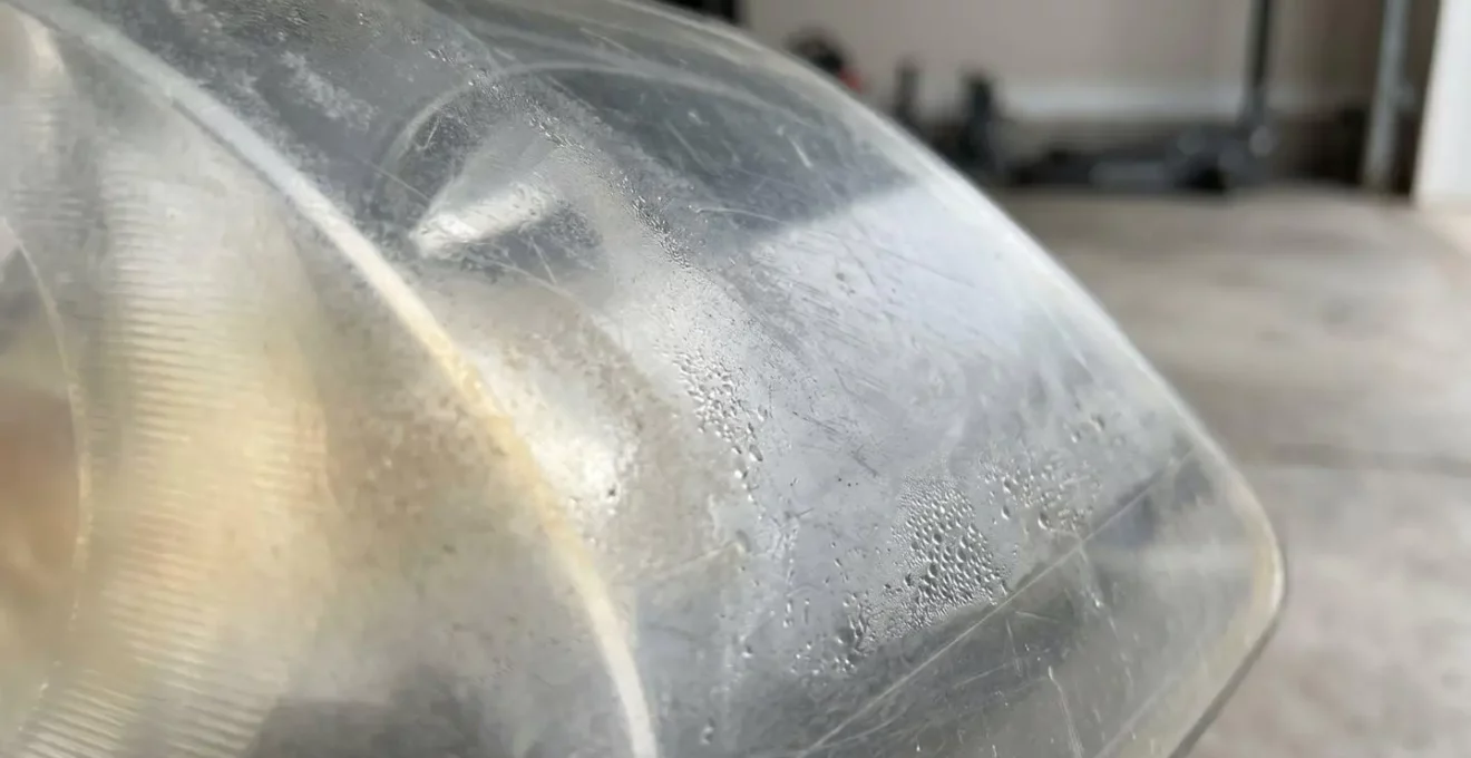 Gros plan sur un phare automobile terni montrant l'opacification du plastique nécessitant un polissage avant le contrôle technique